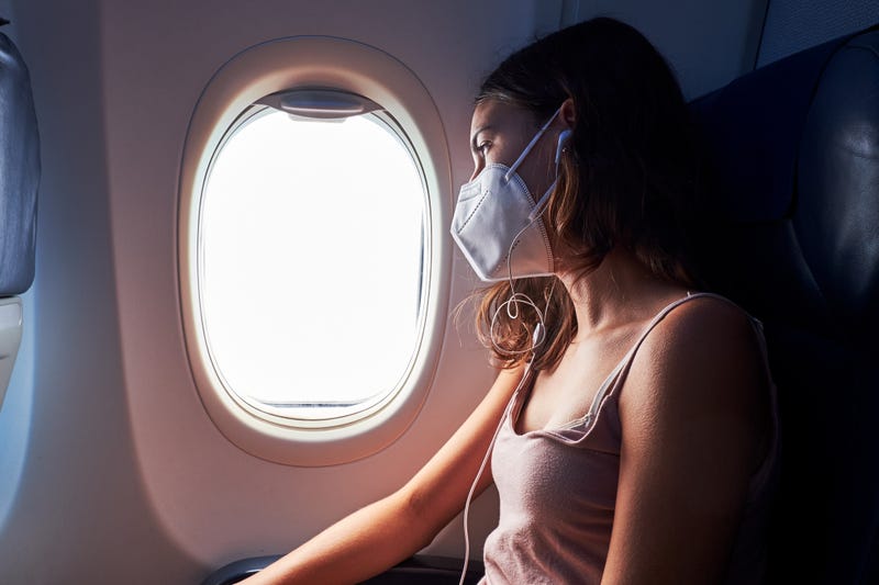 pasajera en un avión con mascarilla
