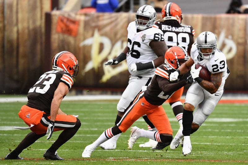 Raiders running back Devontae Booker rushes the football past Browns cornerback Denzel Ward