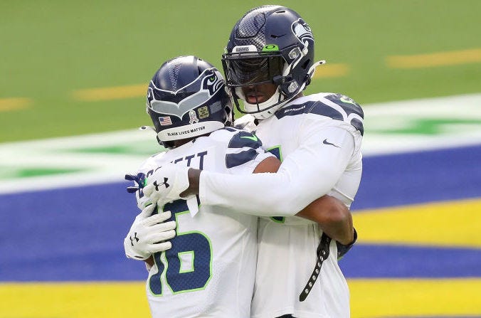 Tyler Lockett, left, and D.K. Metcalf hug.