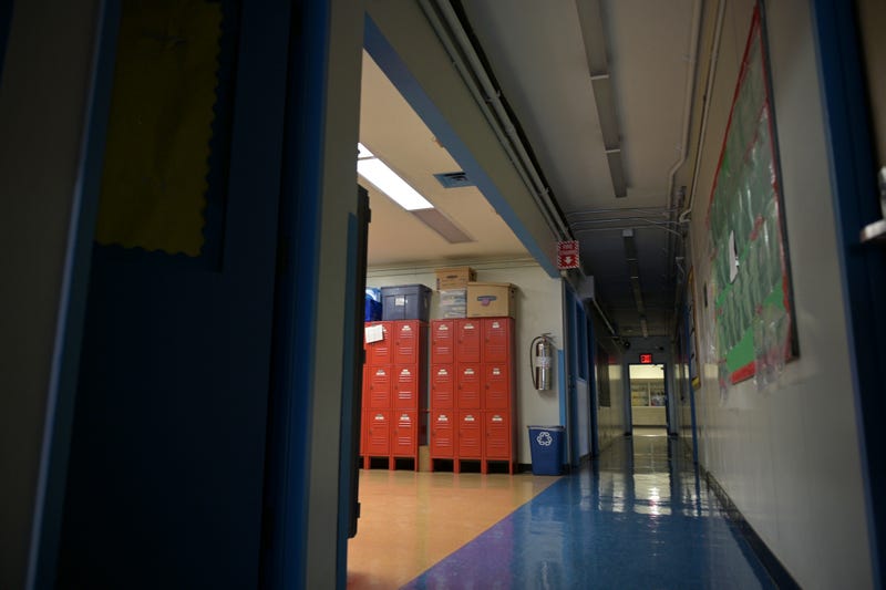 A hallway is empty with most of the lights off on what would otherwise be a blended learning school day on November 19, 2020 at Yung Wing School P.S. 124 in New York City