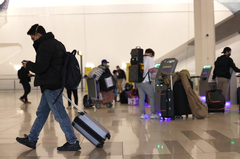 A man walks past people using kiosks to check in for their flights at LaGuardia Airport on November 25, 2020 in Queens.