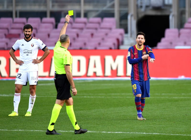 Lionel Messi of Barcelona is shown a yellow card after removing his shirt whilst celebrating after scoring their sides fourth goal while wearing a Newell's Old Boys shirt with the number 10 on the back in memory of former footballer, Diego Maradona, who recently passed away during the La Liga Santander match between FC Barcelona and C.A. Osasuna at Camp Nou on November 29, 2020 in Barcelona, Spain. Sporting stadiums around Spain remain under strict restrictions due to the Coronavirus Pandemic as Government social distancing laws prohibit fans inside venues resulting in games being played behind closed doors.