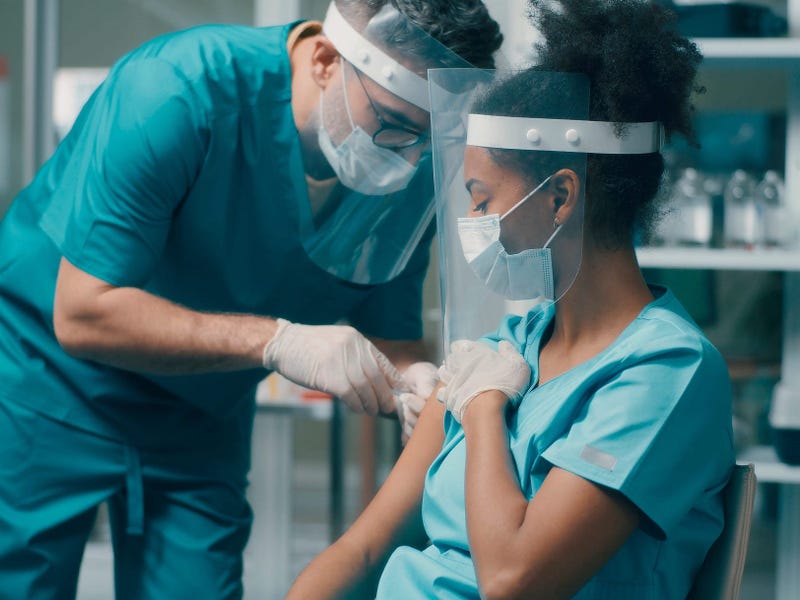Hospital worker getting vaccinated stock photo.