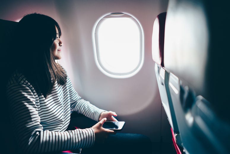Smiling teenager looking out plane window