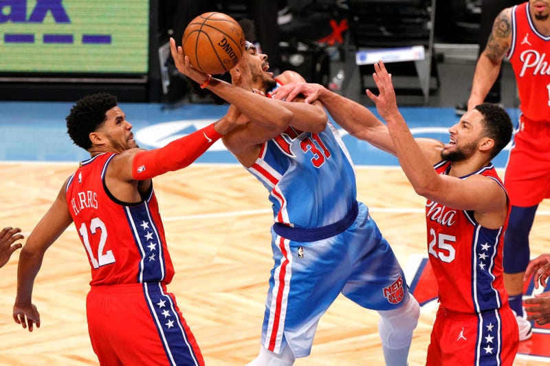 Jarrett Allen #31 of the Brooklyn Nets controls the ball as Tobias Harris #12 and Ben Simmons #25 of the Philadelphia 76ers defend.