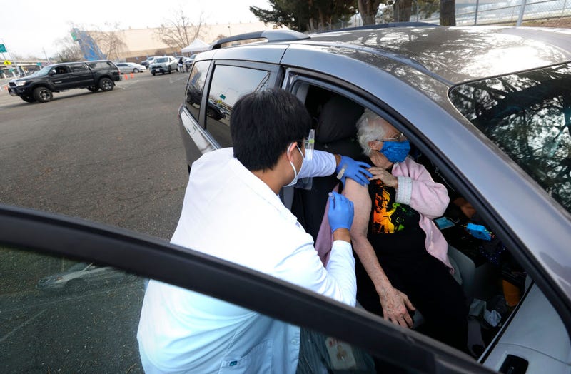 Safeway pharmacist Preston Young (L) administers a Moderna COVID-19 vaccination to Cecile Lusby (R) during a drive-thru COVID-19 vaccination clinic at the Sonoma County Fairgrounds on January 13, 2021 in Santa Rosa, California. Sonoma County health workers received COVID-19 vaccinations during a drive-thru clinic that was hosted by Sonoma County and Safeway.
