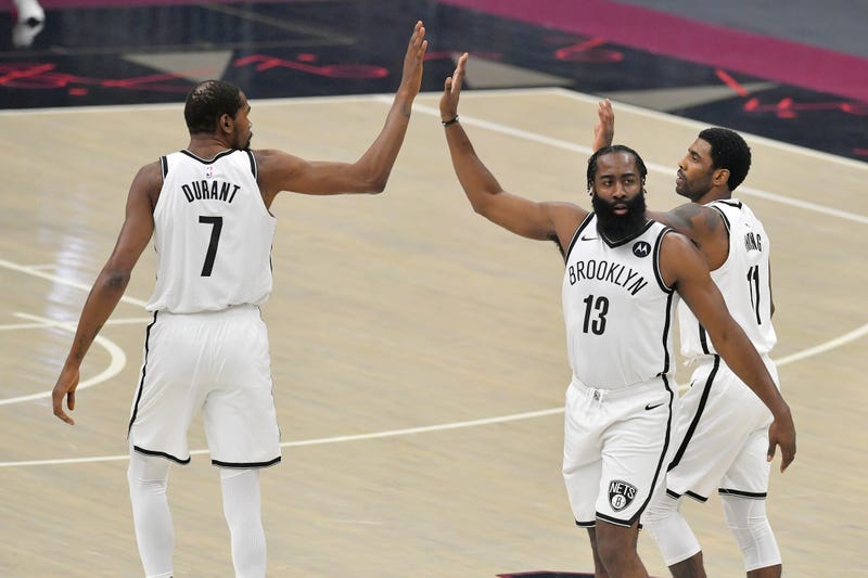 Nets stars Kevin Durant, Kyrie Irving, and James Harden high-five.