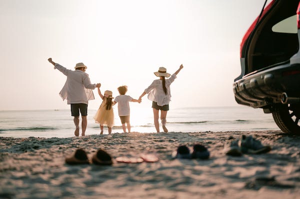 Happy family running on the beach in the sunset