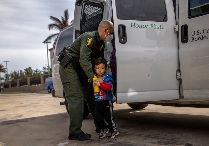 A U.S. Border Patrol agent delivers a young asylum seeker and his family to a bus station on February 26, 2021 in Brownsville, Texas. U.S. immigration authorities are now releasing many asylum seeking families after detaining them while crossing the U.S.-Mexico border. The immigrant families are then free to travel to destinations throughout the U.S. while awaiting asylum hearings.
