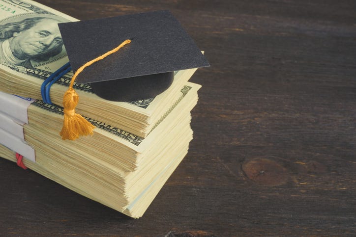 stack of cash with graduation cap