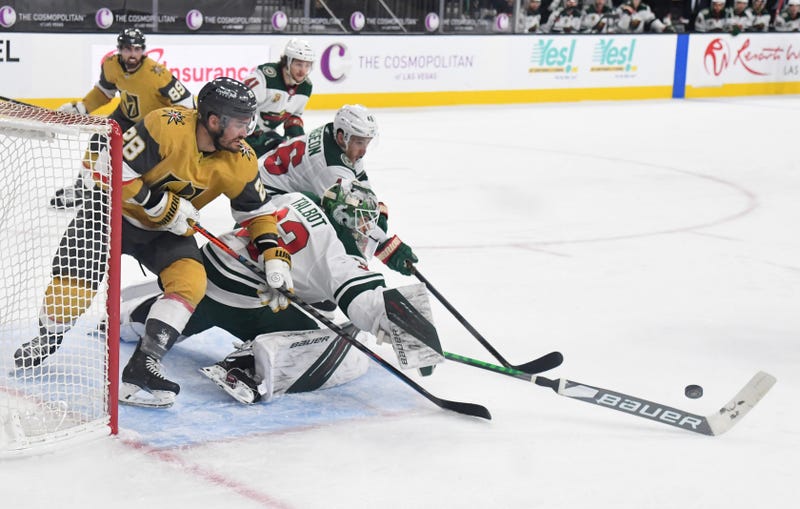 William Carrier #28 of the Vegas Golden Knights skates behind Cam Talbot #33 of the Minnesota Wild to try to get a rebound as Jared Spurgeon #46 of the Wild defends in the third period of their game at T-Mobile Arena on April 3, 2021 in Las Vegas, Nevada
