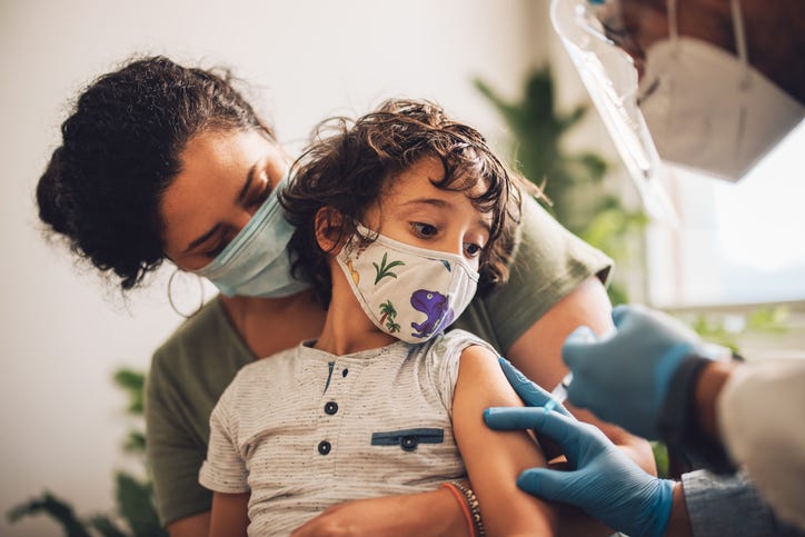 A child receiving a COVID-19 shot.