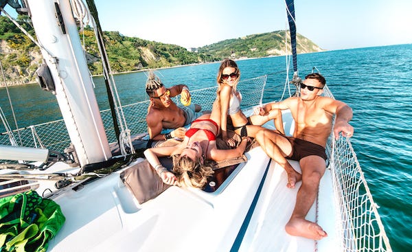 Spoiled, rich friends relaxing on a sailboat