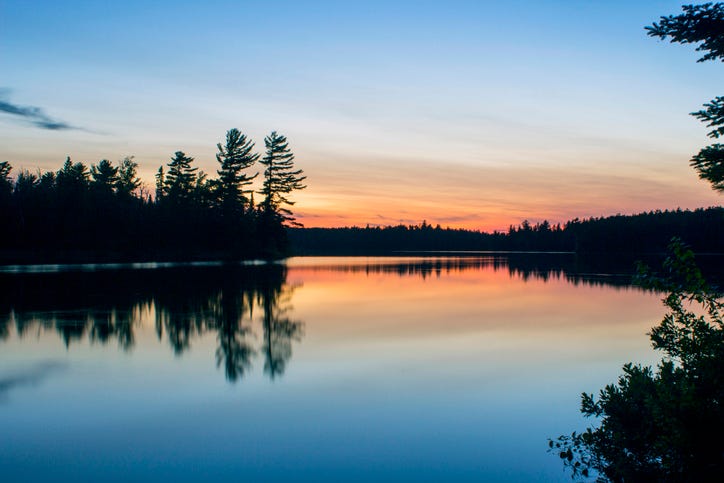 A Wide Angle Shot of Twilight Sky over the Boundary Waters Reflecting in a Calm Disappointment Lake in Northern Minnesota.