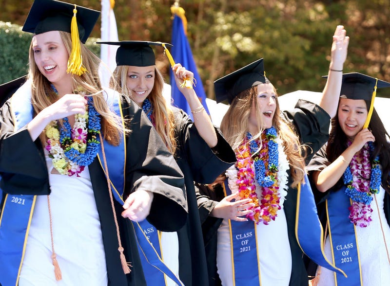 WESTWOOD, CALIFORNIA - JUNE 11: Graduating UCLA students celebrate while walking the stage for their commencement ceremony at Drake Stadium on June 11, 2021 in Westwood, California. Up to 230 students per hour were able to participate in the graduate procession. Each graduate was allowed two guests and were permitted to remove their masks before crossing the stage.