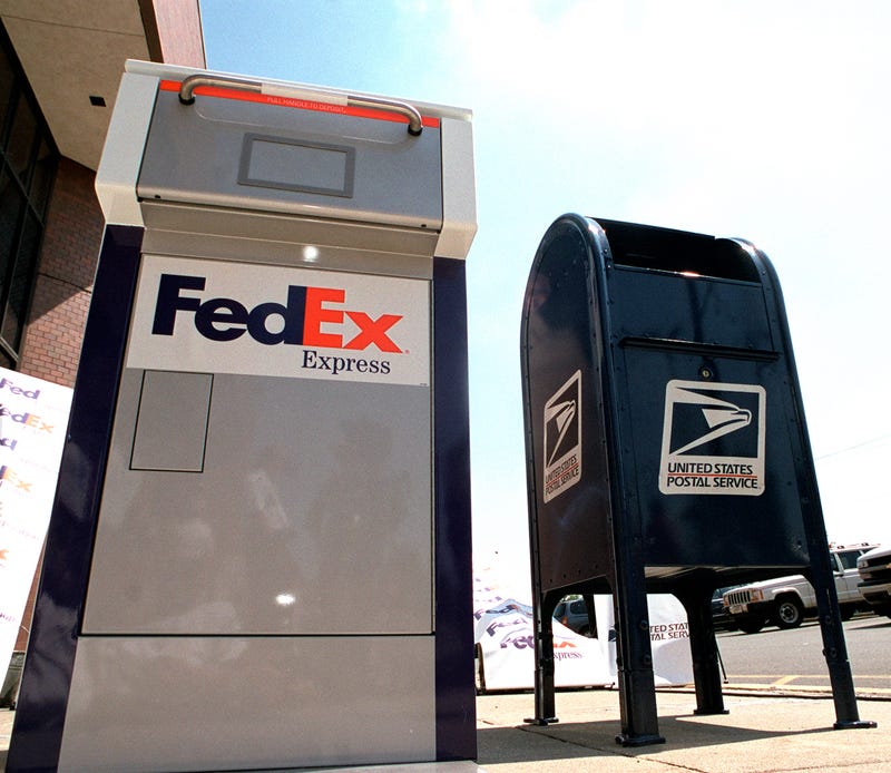 A FedEx drop box sits next to a US mail box at the announcement of FedEx and the US Postal Service''s business aggreement June 19, 2001 in Washington, DC.