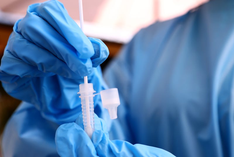 A registered nurse stirs a nasal swab in testing solution after administering a COVID-19 test at Sameday Testing on July 14, 2021 in Los Angeles, California.