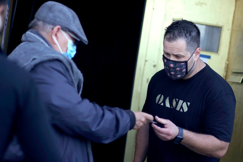 A doorman at Oasis checks a customer's vaccination card before allowing him to enter on July 29, 2021 in San Francisco, California.