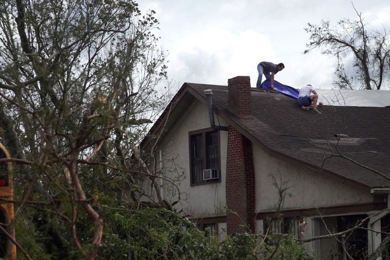 LAPLACE, LOUISIANA - AUGUST 30: Workers tarp the roof of a home damaged by Hurricane Ida on August 30, 2021 in Laplace, Louisiana. Ida made landfall August 29 as a category 4 storm southwest of New Orleans.