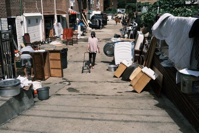 People clean up their flooded homes in a Queens neighborhood that saw massive flooding and numerous deaths following a night of heavy wind and rain from the remnants of Hurricane Ida on Sept. 3, 2021