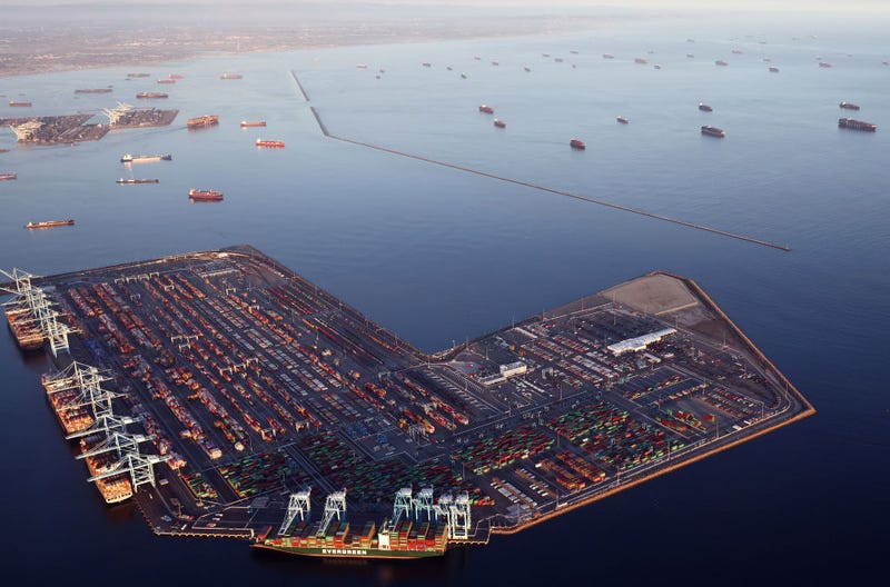 In an aerial view, container ships (Top R) are anchored by the ports of Long Beach and Los Angeles as they wait to offload on September 20, 2021 near Los Angeles, California. Amid a record-high demand for imported goods and a shortage of shipping containers and truckers, the twin ports are currently seeing unprecedented congestion. On September 17, there were a record total of 147 ships, 95 of which were container ships, in the twin ports, which move about 40 percent of all cargo containers entering the U.S. (Photo by Mario Tama/Getty Images)