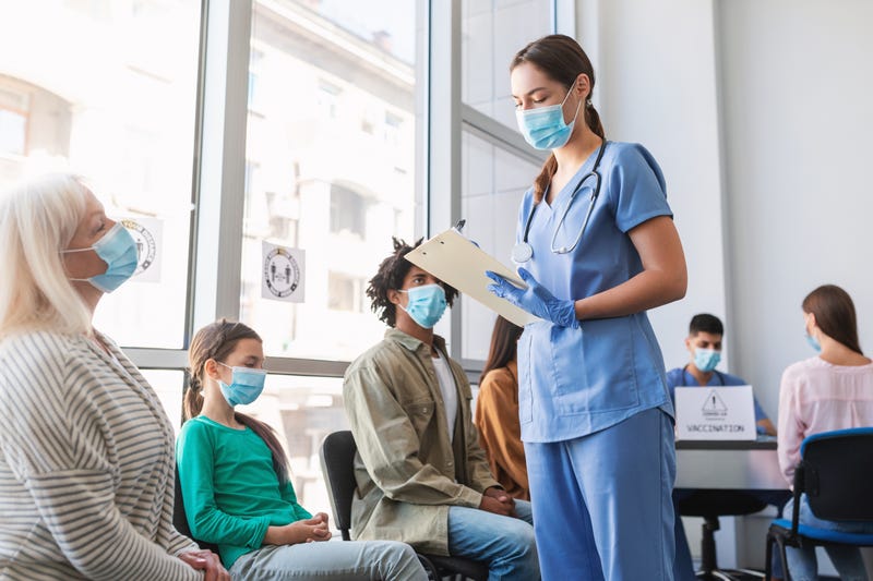 Several people sit in a waiting room at a doctor's office