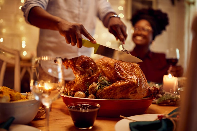Family cutting turkey on Thanksgiving day