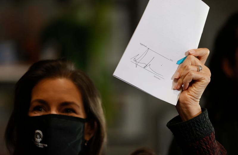 Oakland Mayor Libby Schaff holds up Senate Bill 314 after California Gov. Gavin Newsom signed it during a news conference at Kingston 11 Cuisine on October 08, 2021 in Oakland, California.