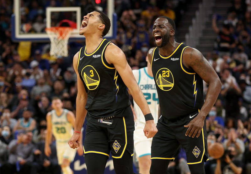 Jordan Poole #3 and Draymond Green #23 of the Golden State Warriors react after Poole made a three-point basket against the Charlotte Hornets in the first half at Chase Center on November 03, 2021 in San Francisco, California.