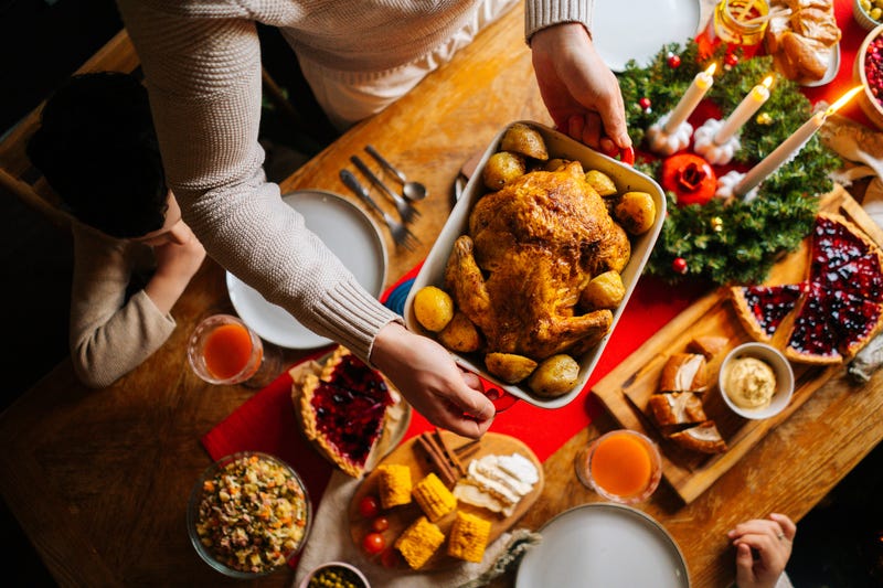 Person placing a turkey on their table for Thanksgiving dinner.