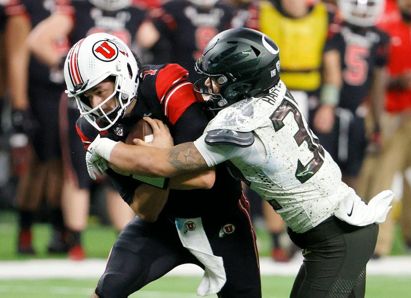 Quarterback Cameron Rising #7 of the Utah Utes is tackled by safety Jordan Happle #32 of the Oregon Ducks after running for 9 yards and a first down during the Pac-12 Conference championship game at Allegiant Stadium on December 3, 2021 in Las Vegas, Nevada.