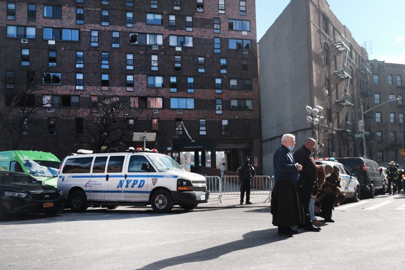 Local clergy members gather and pray in front of a Bronx apartment building a day after a fire swept through the complex killing at least 17 people and injuring dozens of others, many of them seriously on January 10, 2022 in New York City