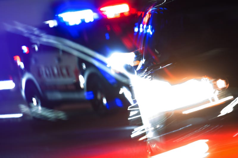 Hot Pursuit Police Traffic Chase at Night. Police Cruiser Next to Running Out DUI Driver Conceptual Photo with Motion Blurs. Police Enforcement Theme.