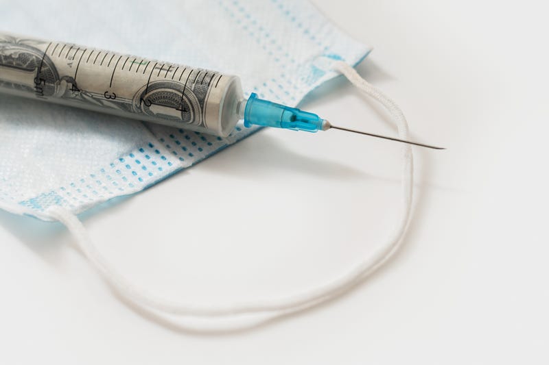 Money in a syringe stock photo.
