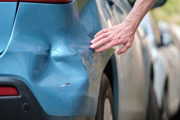 Looking At A Dented Car