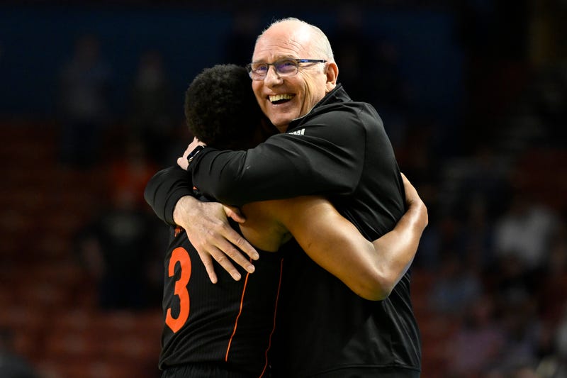 Miami Hurrianes head basketball coach celebrates with player Charlie Moore after beating Auburn in early 2022.