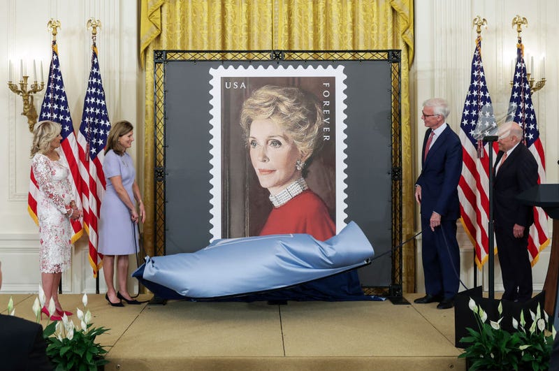 First Lady Jill Biden, Anne Peterson, Nancy Reagan’s niece, Fred Ryan, Chairman of the Board of Trustees of The Ronald Reagan Presidential Foundation and Institute and Louis DeJoy, U.S. Postal Service Postmaster General, unveil the Nancy Regan stamp, in the East Room at the White House on June 06, 2022 in Washington, DC. The U.S. Postal Service unveiled the stamp honoring the legacy of First Lady Nancy Reagan and her role in helping to shape President Ronald Regan's Administration. (Photo by Kevin Dietsch/Getty Images)
