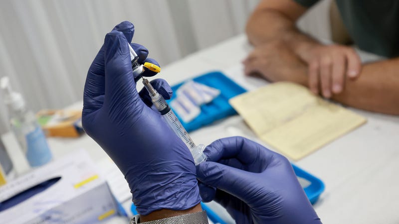 A healthcare worker prepares to administer a vaccine to a person for the prevention of monkeypox.