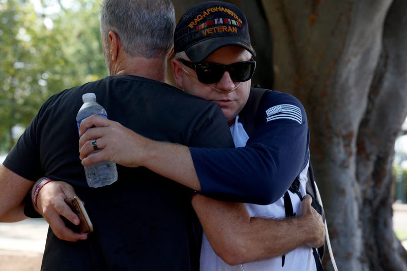 Jon Stewart hugs veteran on Capitol Hill.