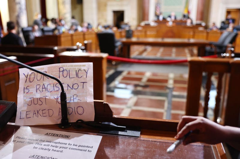 A sign rests against the microphone stand as protestors demonstrate while the L.A. City Council holds its first in-person meeting since voting in new president Paul Krekorian in the wake of a leaked audio recording on October 25, 2022 in Los Angeles, California.