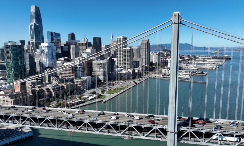 In an aerial view, cars drive by the San Francisco skyline as they cross the San Francisco-Oakland Bay Bridge on October 27, 2022 in San Francisco, California.