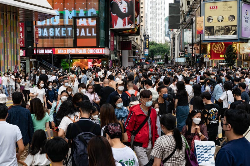 Residents cross an intersection at a shopping district on Oct. 30, 2022, in Hong Kong, China.