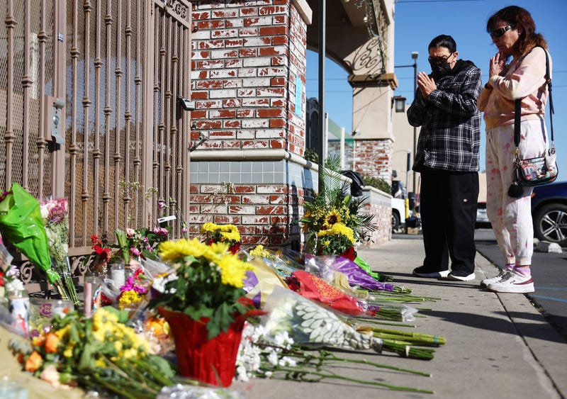 People stand at a makeshift memorial outside the scene of a deadly mass shooting at a ballroom dance studio on January 23, 2023 in Monterey Park, California.
