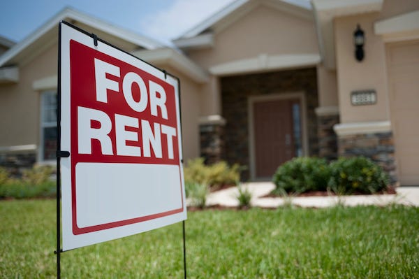 House with "For Rent" sign in yard