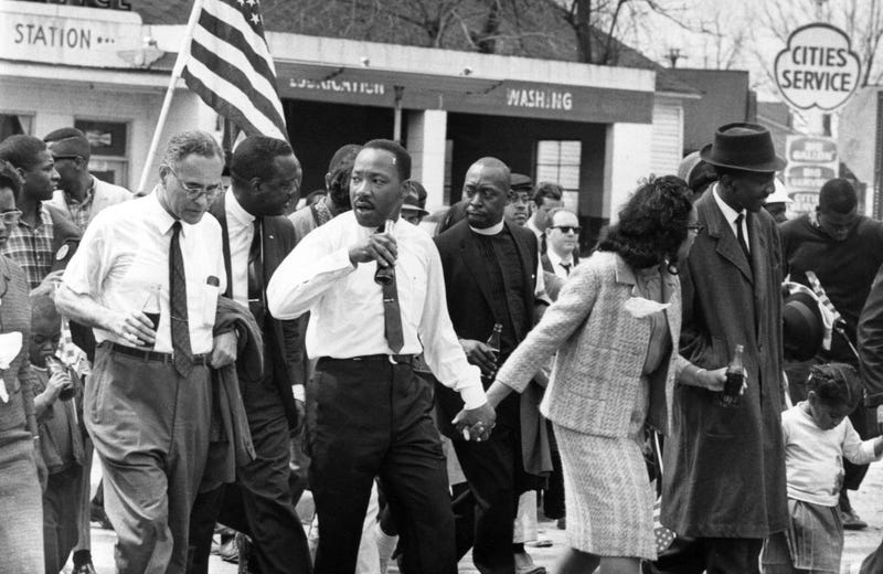 Martin Luther King (1929 - 1968) and his wife Coretta Scott King lead a civil rights march from Selma, Alabama, to the state capital in Montgomery. On the left (holding bottle) is American diplomat Ralph Bunche (1904 - 1971). (Photo by William Lovelace/Express/Getty Images)