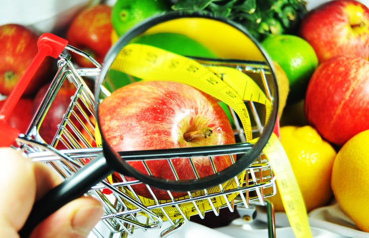 inspecting fruit with magnifying glass at grocery store
