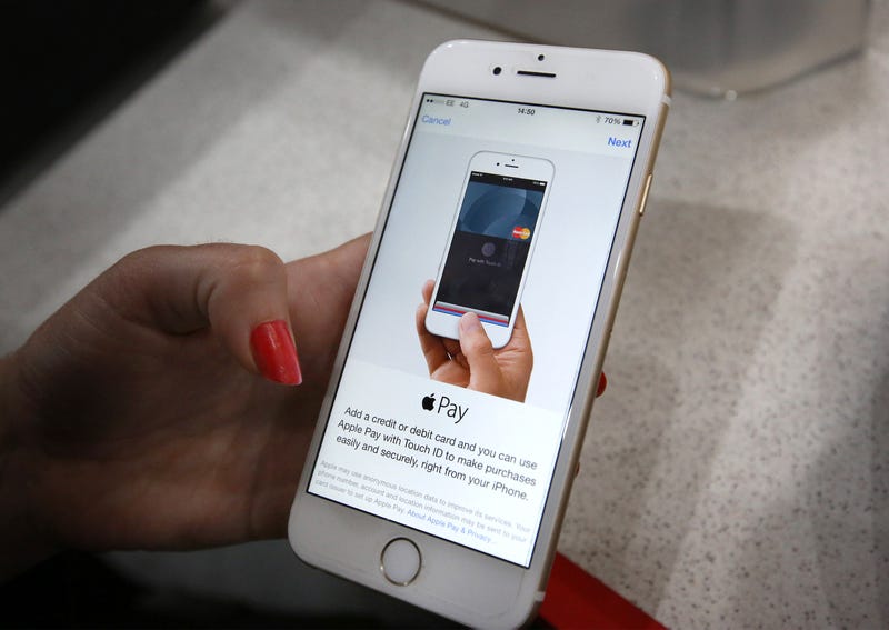 An iPhone is used to make an Apple Pay purchase.