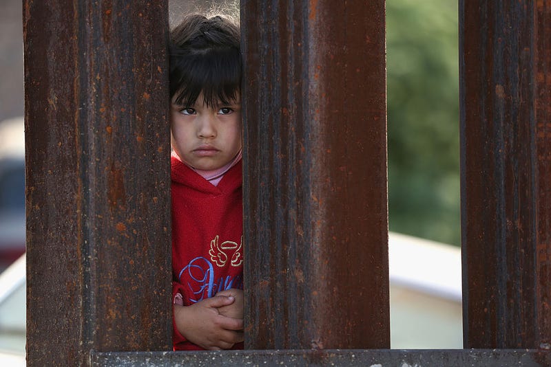 A child on the Mexican side of the U.S.-Mexico border fence looks into Arizona