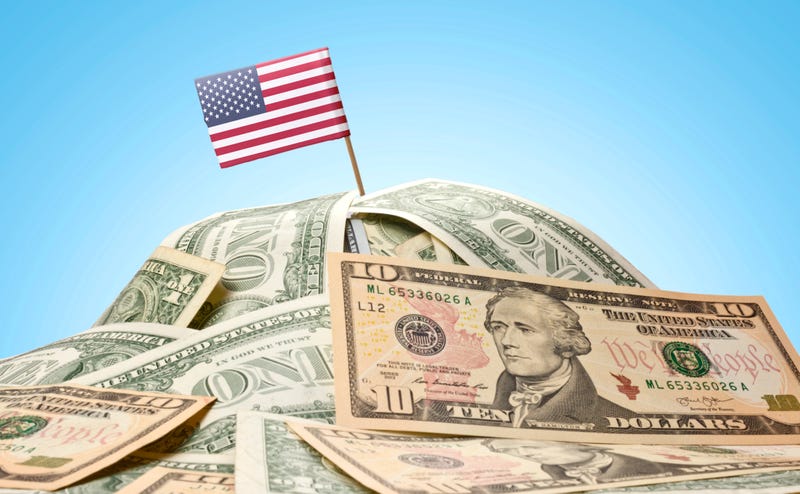 The national flag of USA sticking in a pile of american dollars