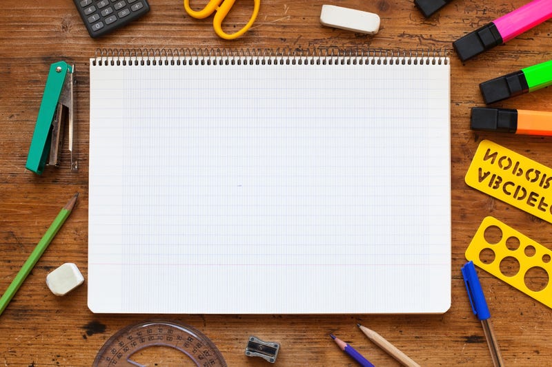 notebooks with other school supplies surrounding it